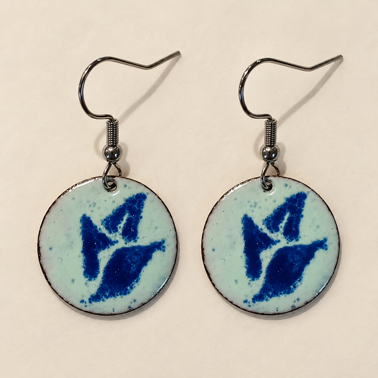 Aretes de cobre esmaltado en blanco con un símbolo azul